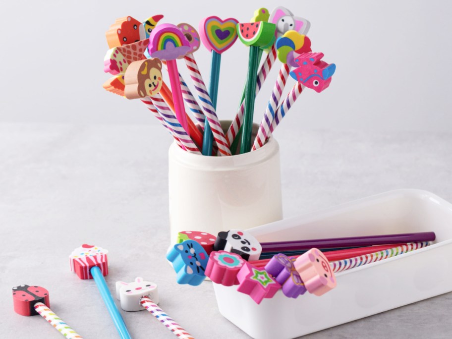 assorted colorful pencils and eraser toppers in a white pencil holder