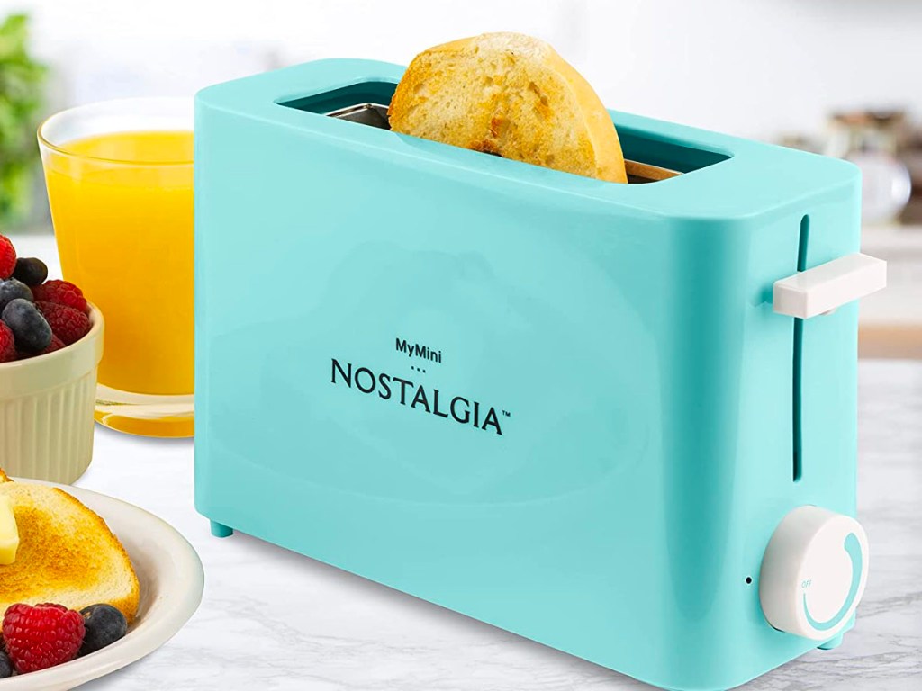 teal nostaglia toaster on counter with cup of orange juice