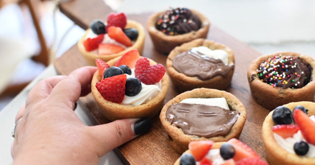 Placing stuffed cookie cups dessert on a wood platter.