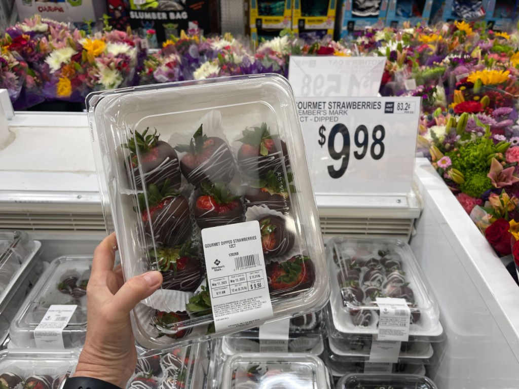 hand holding up chocolate covered strawberries in a box at sams club