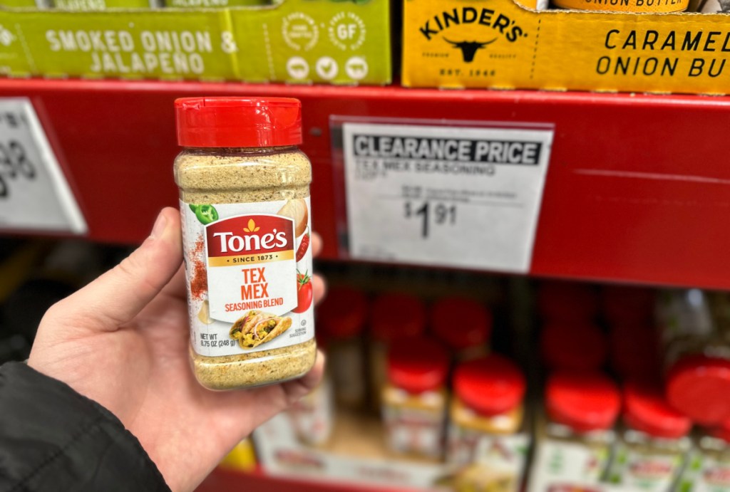 hand holding tex mex tones seasoning in front of a sams club clearance sign