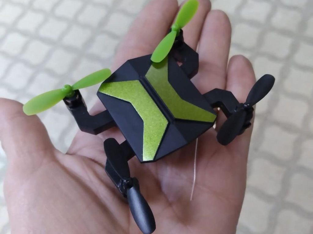 hand holding green mini drone