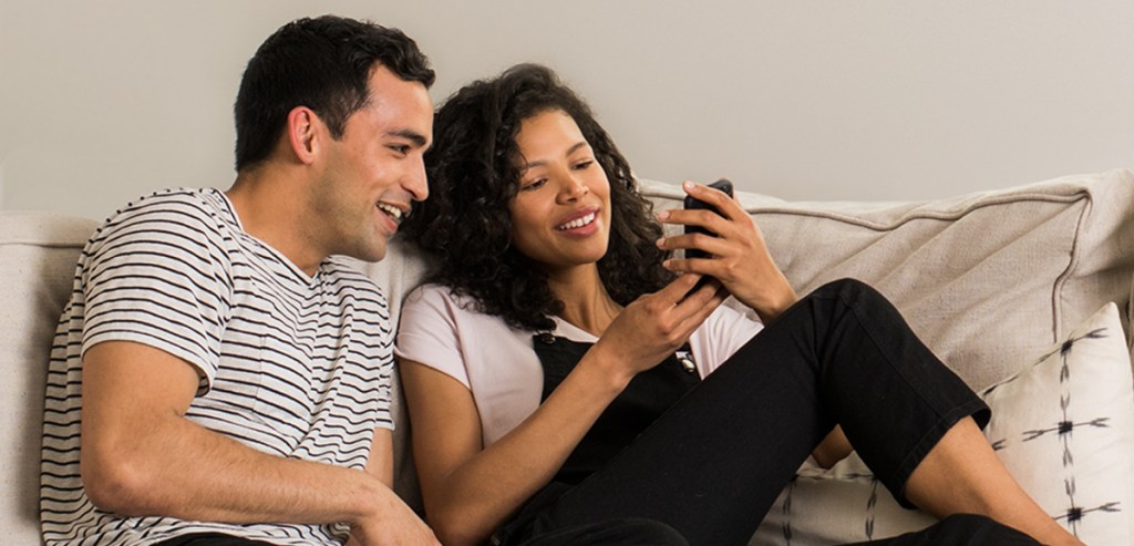 A couple shopping on their phones using Amazon Household