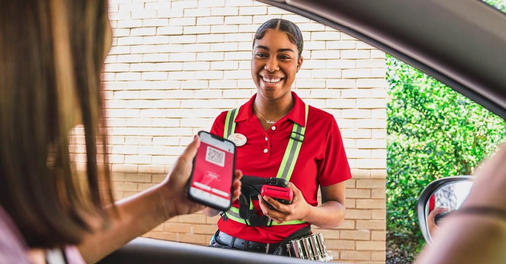 woman using app at Chick-fi-A drive-thru