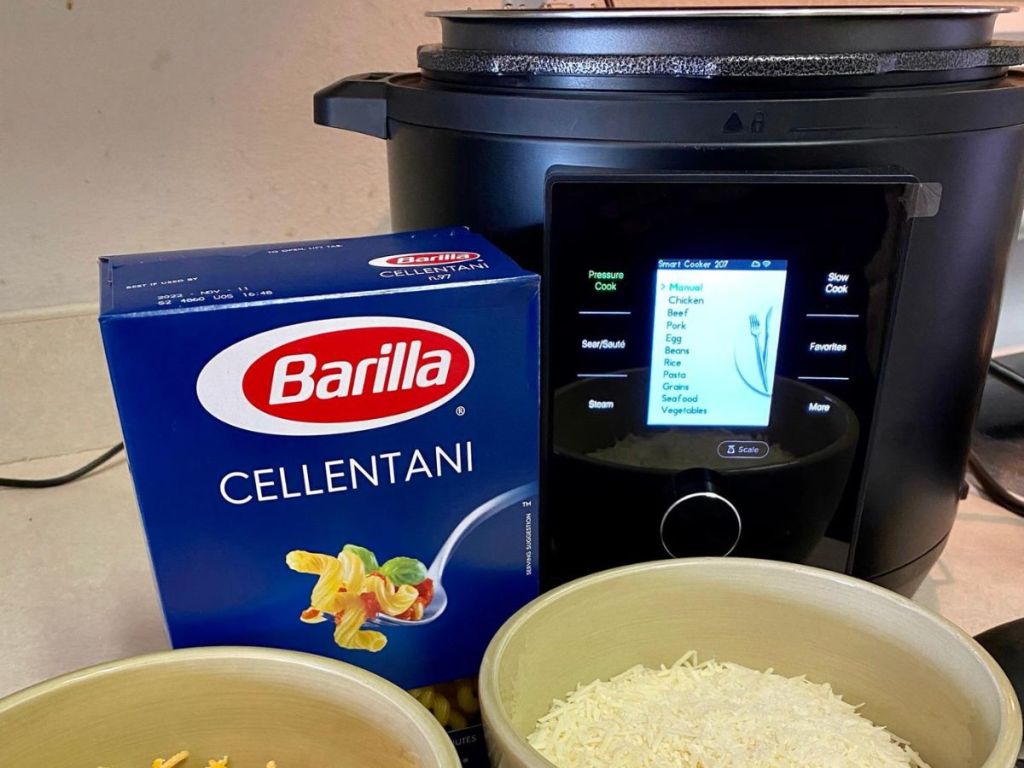 pressure cooker with LCD menu on with box of Barilla noodles beside it