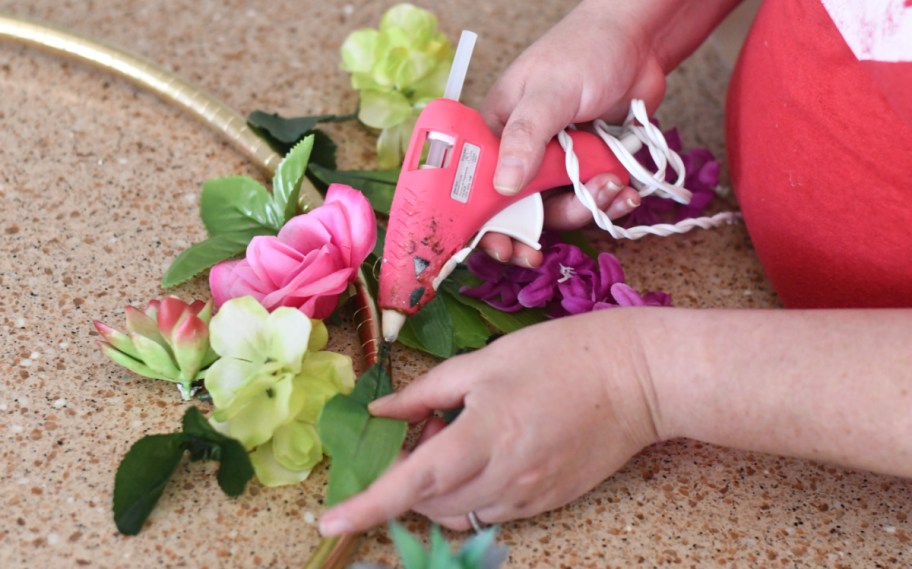 woman creating diy dollar tree wedding decoration ideas like a hula hoop photo display