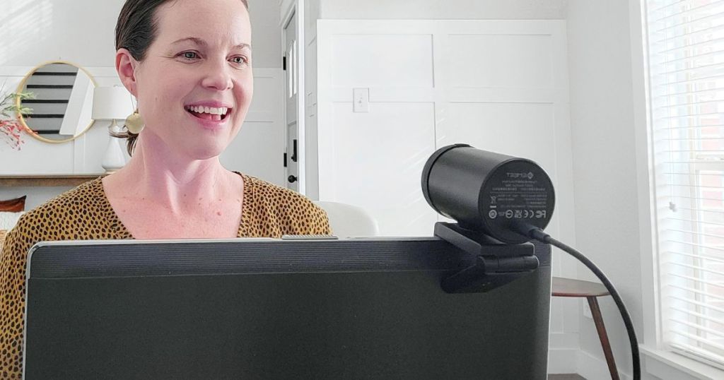 woman talking into camera attached to laptop