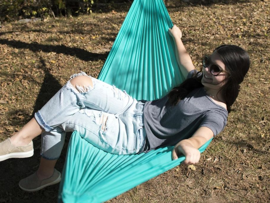 A woman in a green tree hammock