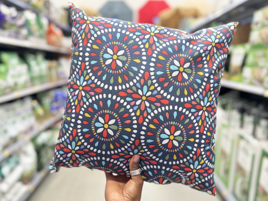 hand holding up a colorful medallion print throw pillow