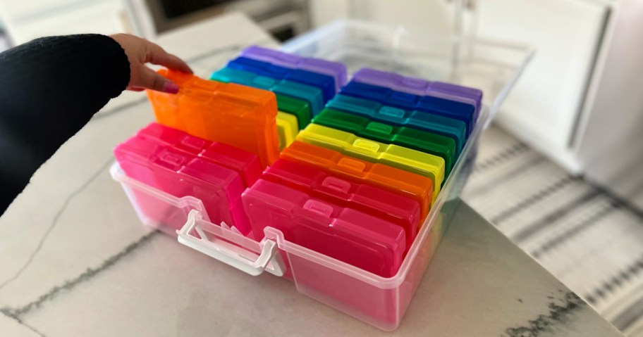 woman grabbing a container from a Rainbow Photo and Craft Keeper by Simply Tidy