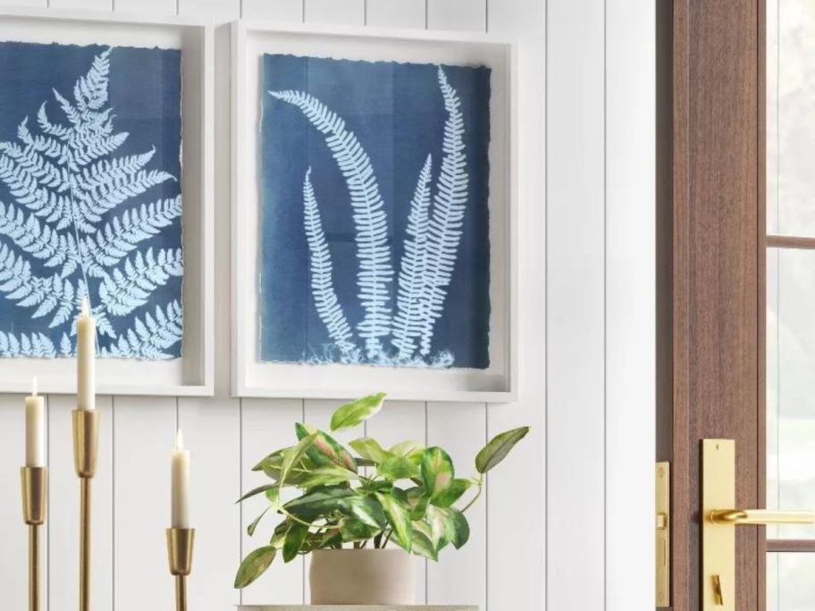 A living room with 2 framed art pieces on the wall in blue and white 