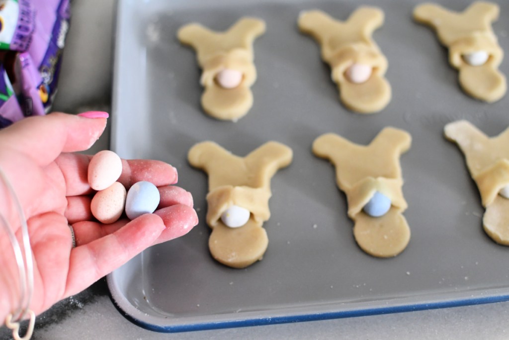 adding an egg to each sugar cookie