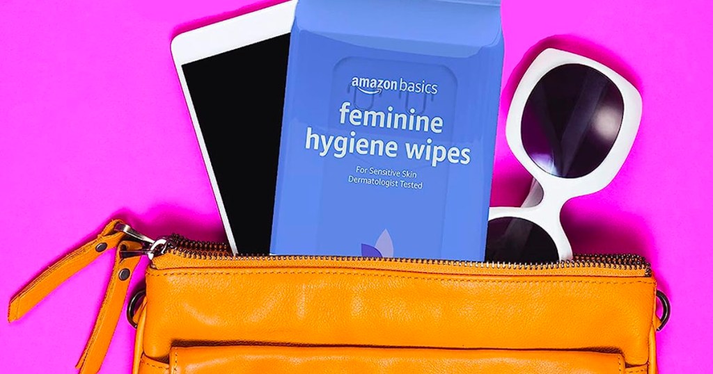 purse open with amazon basics feminine wipes, sunglasses and phone onlineing out of it