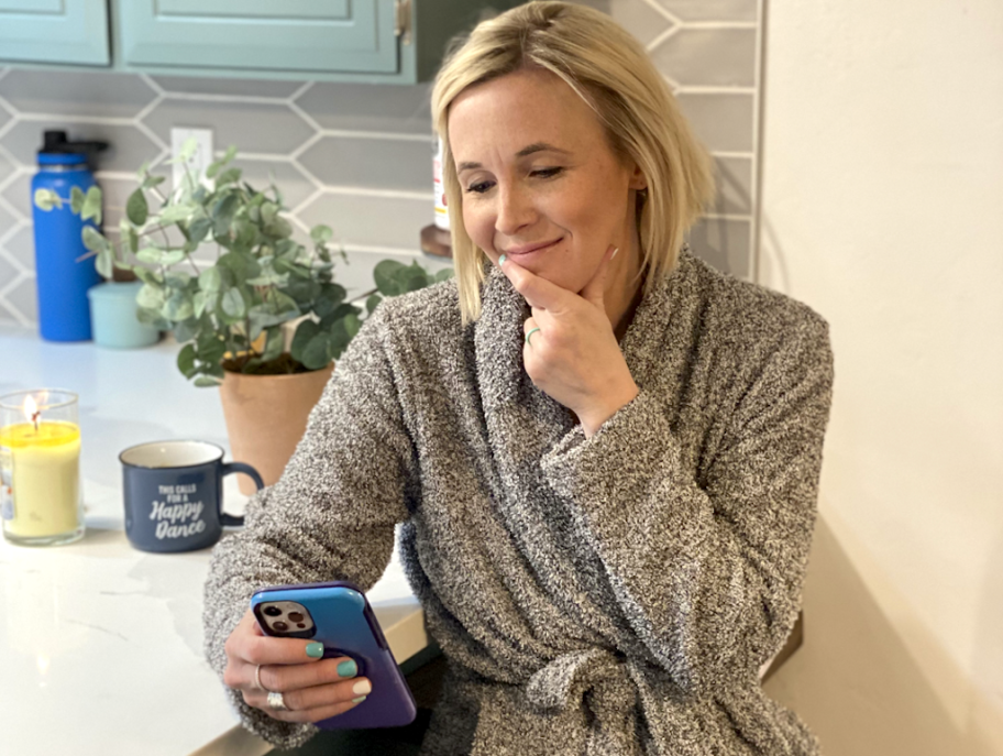 woman sitting at kitchen bar holding phone