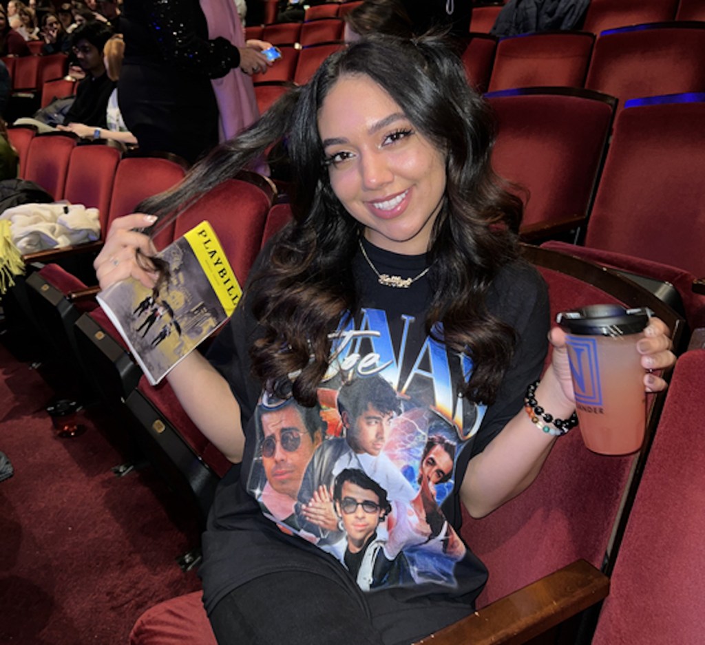 woman sitting in concert seat holding drink