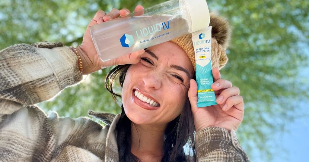 woman with liquid iv packet and water bottle