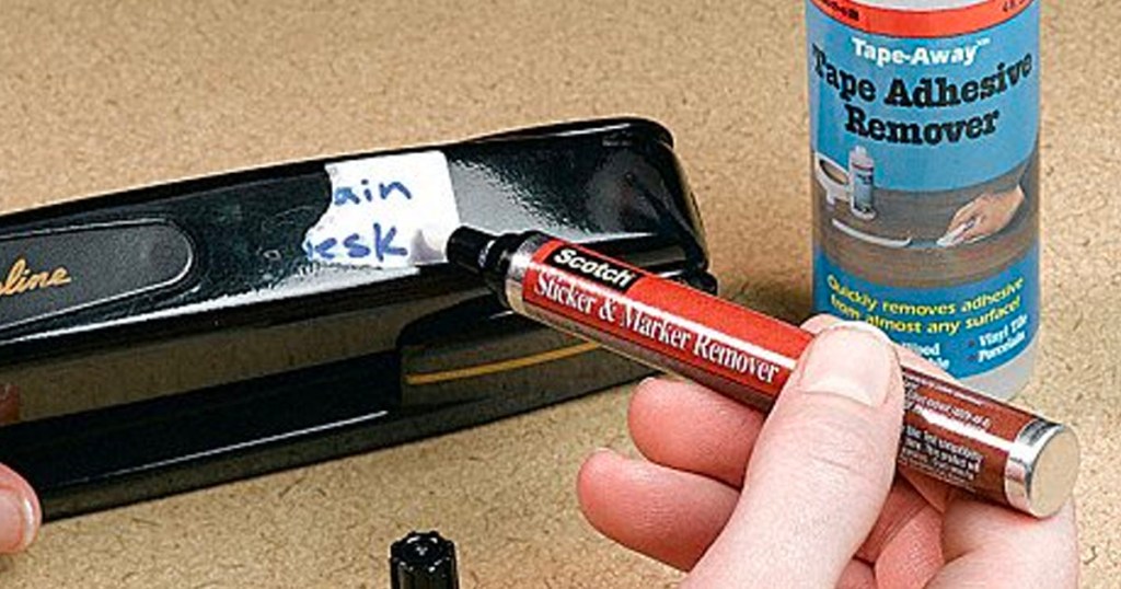 hand using scotch sticker marker to remove marker from item