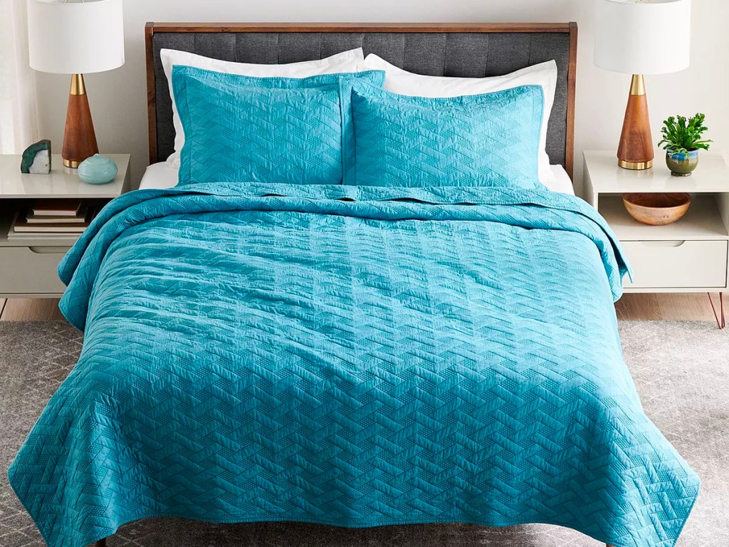 teal quilt set on bed