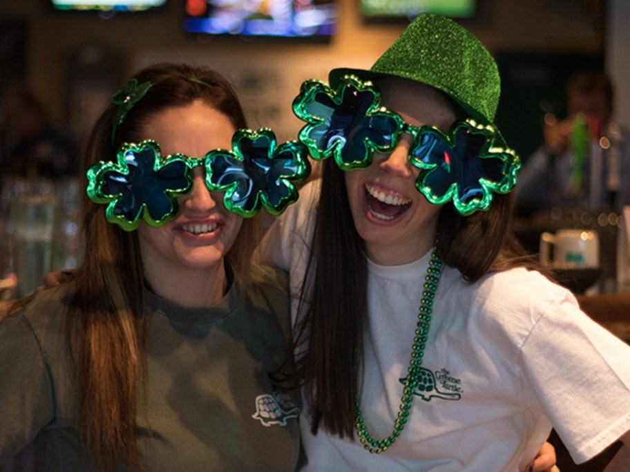 two women wearing shamrock sunglasses