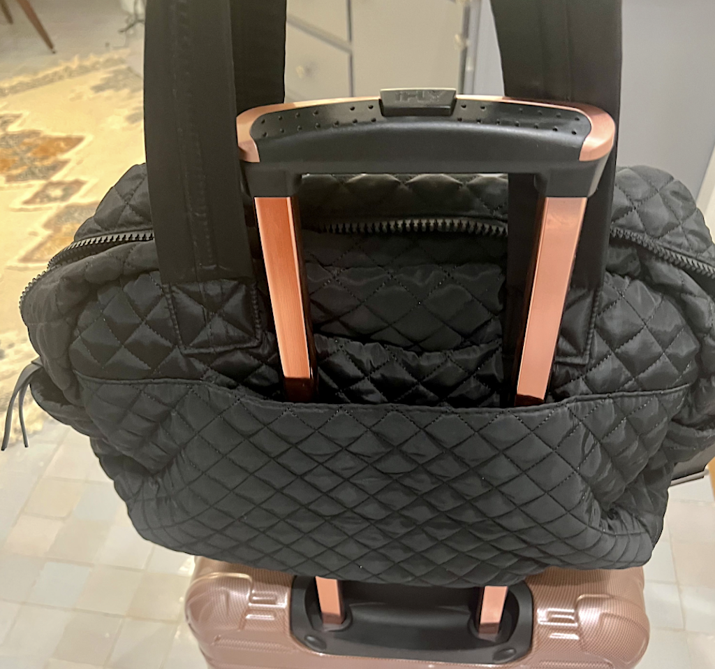 putting weekender bag on luggage 