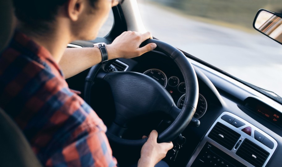 man driving a vehicle who has a good student driver car insurance rate