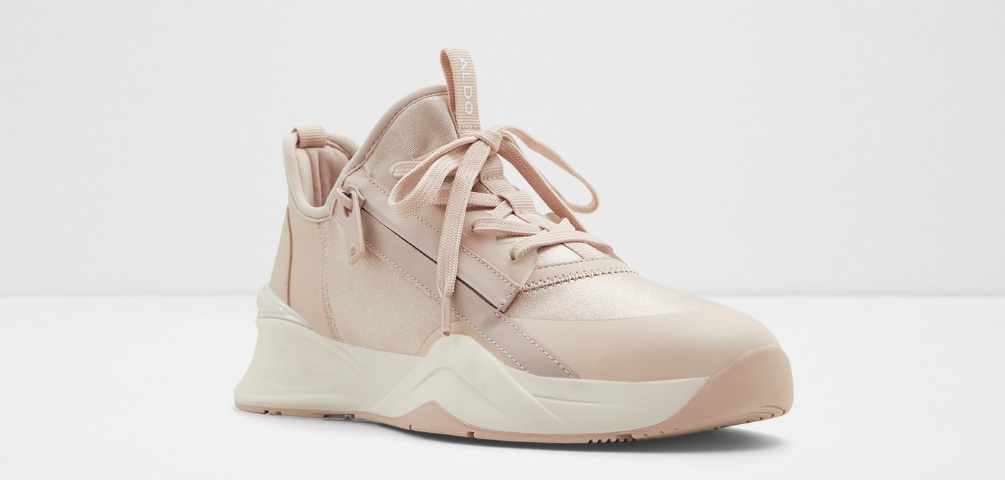 Rose gold sneaker with a zipper on the side and a white sole