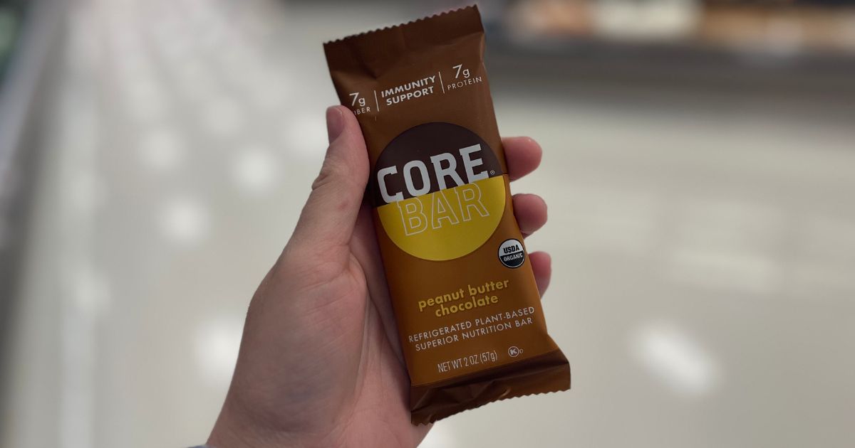 a mans hand holding a Core peanut butter chocolate oat bar