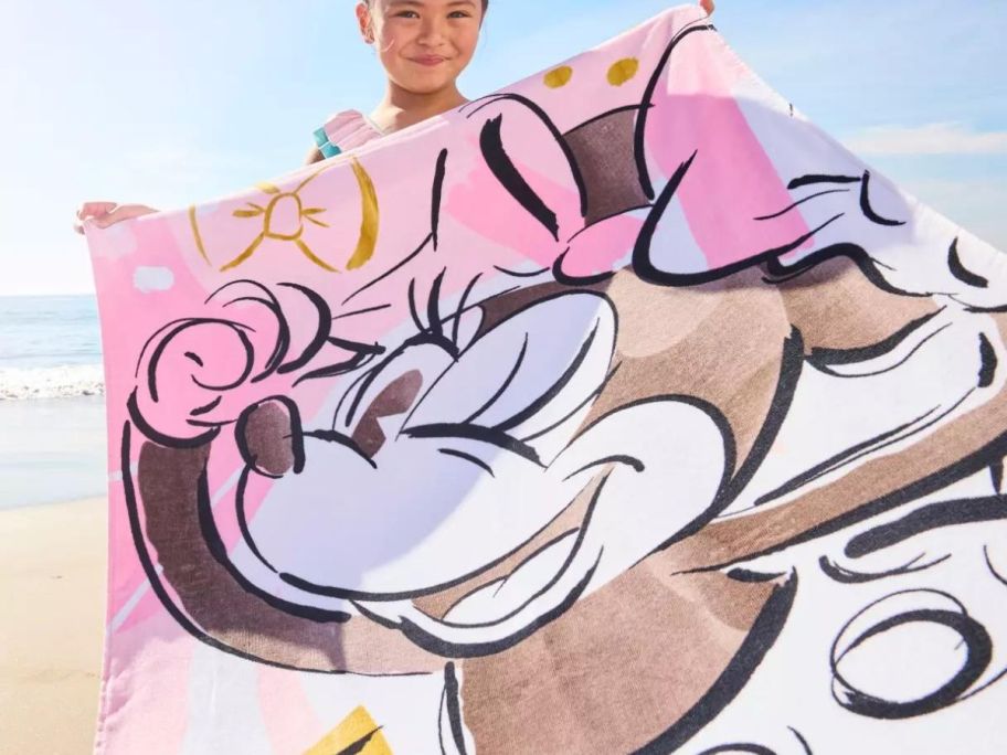 Little girl holding up a Minnie Mouse Beach Towel