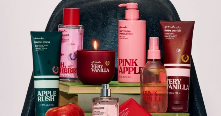 victoria's secret pink beauty items lotions, body mist, shower gels, scrubs on a green chair with books and apples