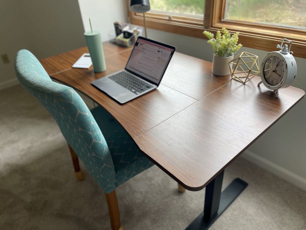 Desk with a onlineputer on it and a teal chair next to it