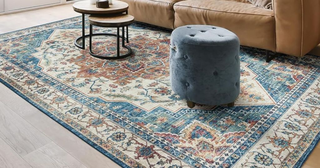 Living room with an area rug in front of the couch with an ottoman and a table on it