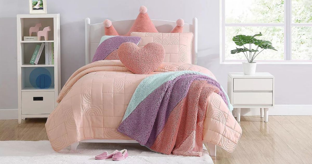 a child's room with a pink onlineforter with a throw blanket and colorful pillows