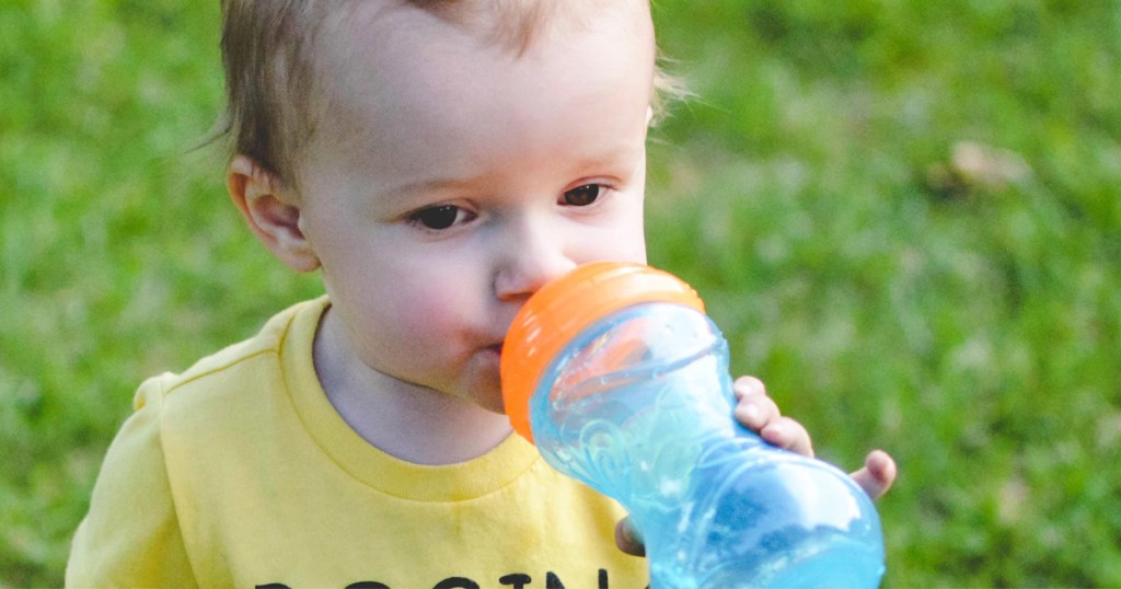 boy sipping on blue and orange sippy cup