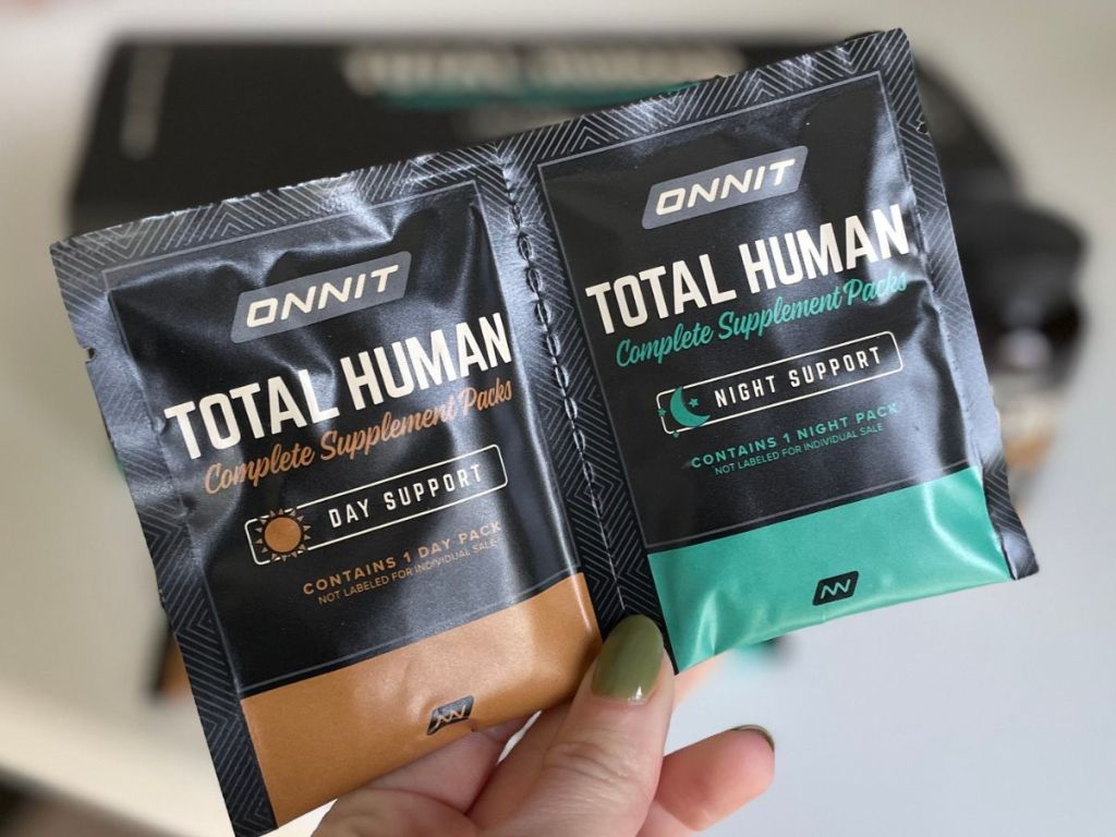 hand holding ONNIT Total Human Packets of vitamins and supplements