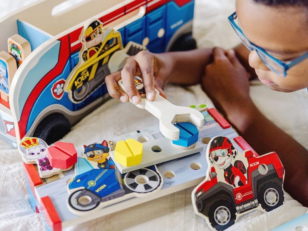 Boy working on a Paw Patrol toy set