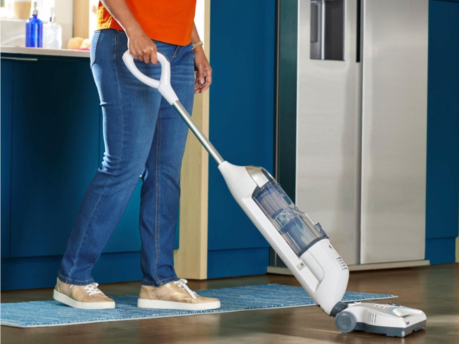 Person vacuuming the floors with cordless vacuum