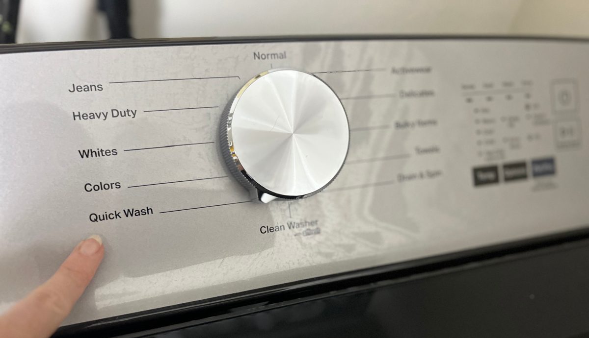 Woman pointing to the Quick Wash cycle on a washing machine
