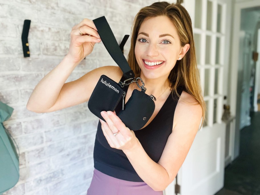 woman holding up Lululemon Wristlet in black