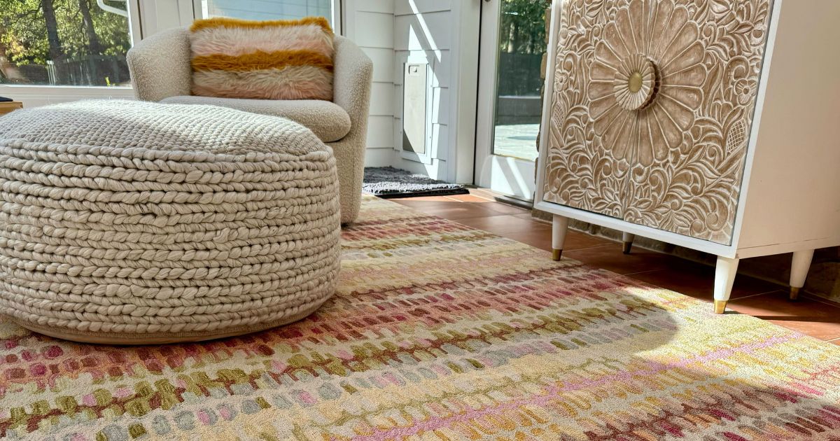 A Wayfair rug with a pouf ottoman and chair on it