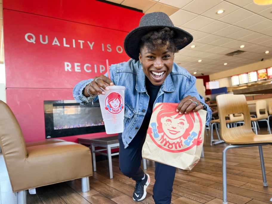 person carrying Wendys bag and Wendys beverage