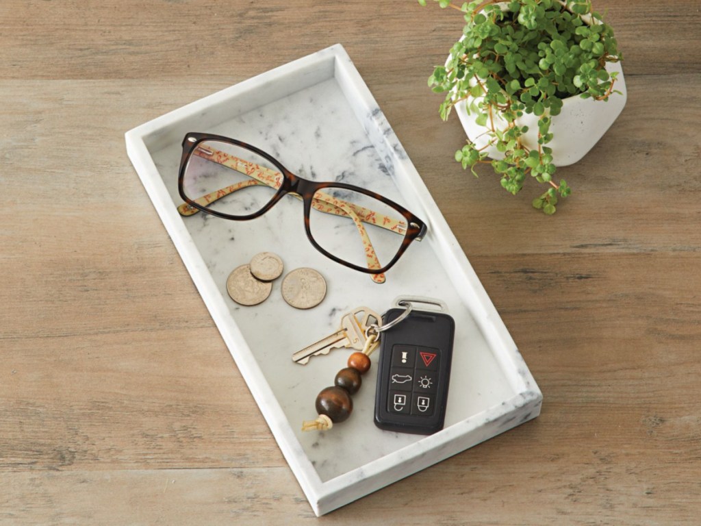 better homes and gardens vanity tray with eyeglasses, coins and keys next to a plant