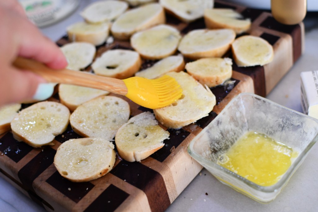 brushing butter onto bagel chips