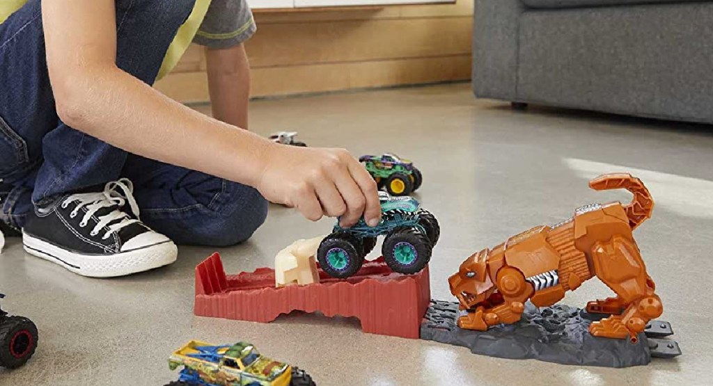 child playing with Hot Wheels Monster Playset on the floor with other trucka