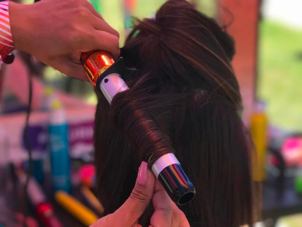 hand using curlipop wand to curl hair