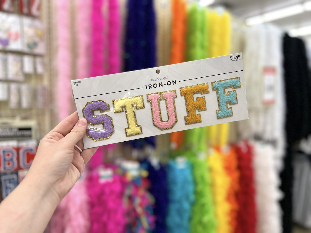 woman holding stuff iron on at Hobby Lobby 