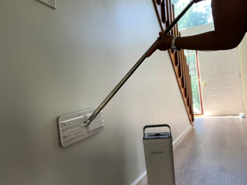 woman cleaning walls with a joymoop mop