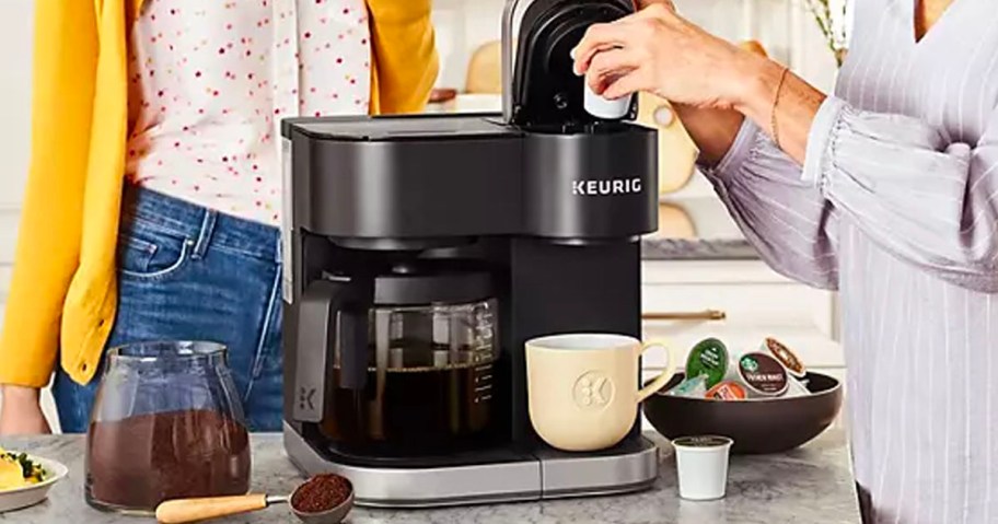 hand adding coffee grounds to coffee maker