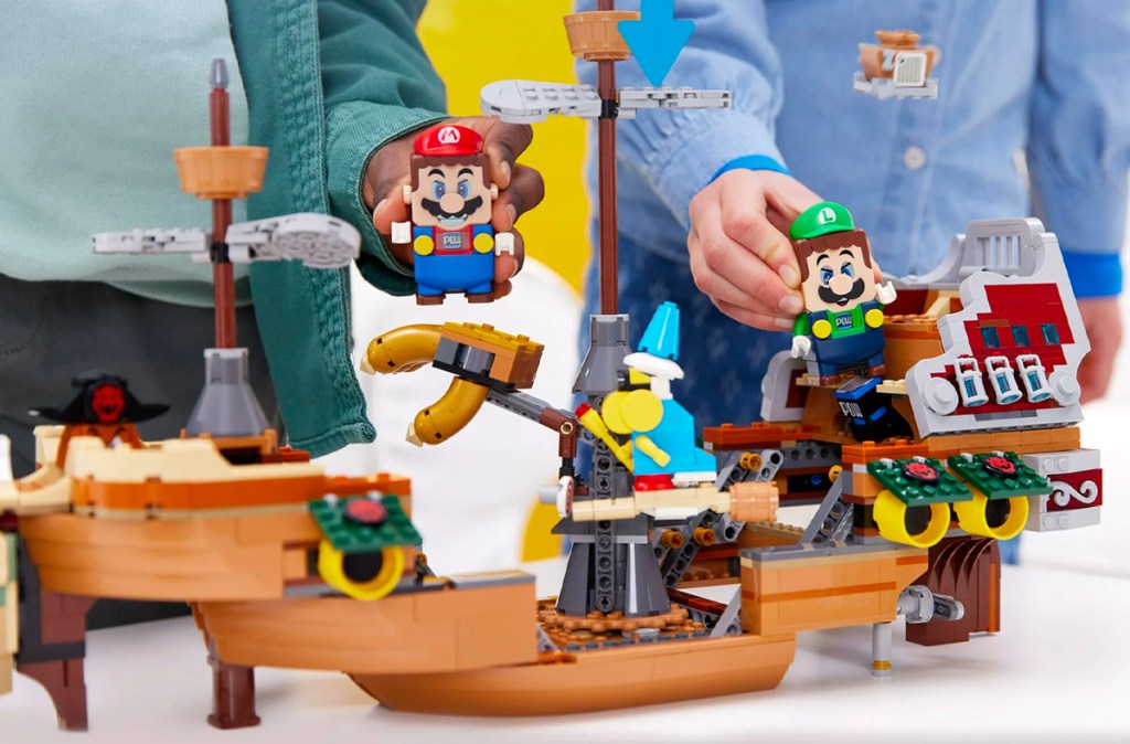 two kids playing with super mario bowsers airship lego set