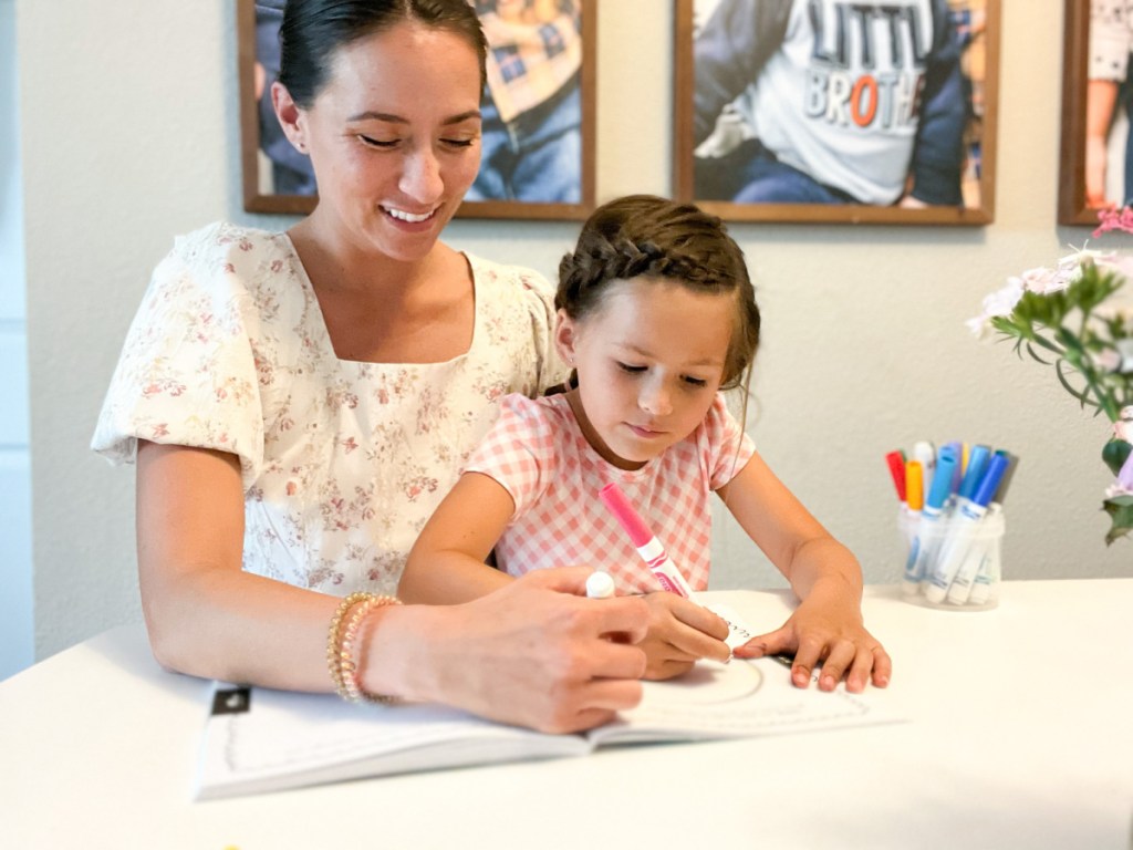 mom and daughter coloring at table