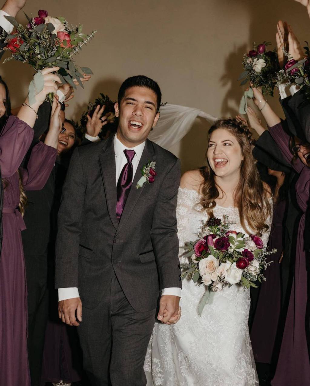 married couple walking down aisle with wedding guests